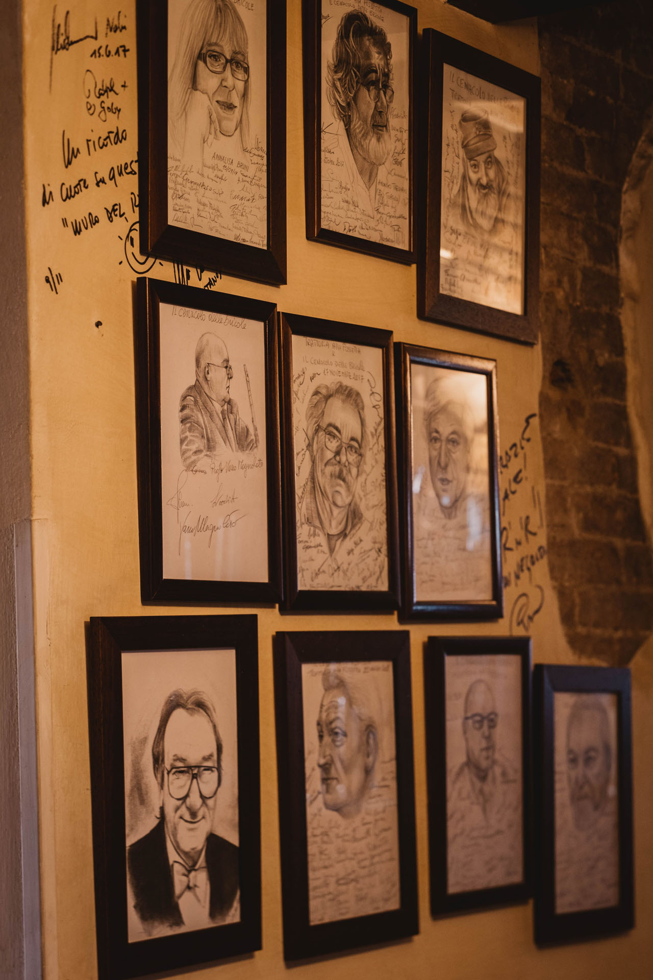 Caricature di persone note appese a parete, in un passaggio interno alla trattoria.