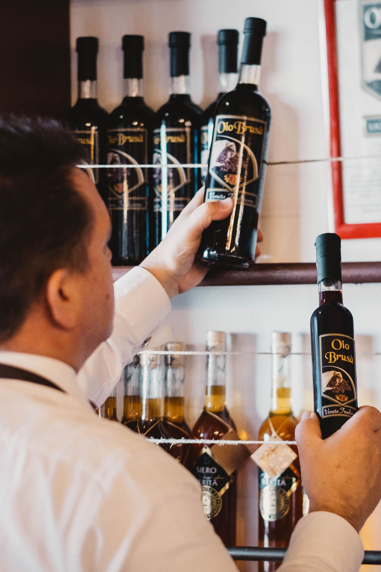 Alessandro Doretto mentre ripone l’Oio Brusà, famosissimo liquore al caffè.