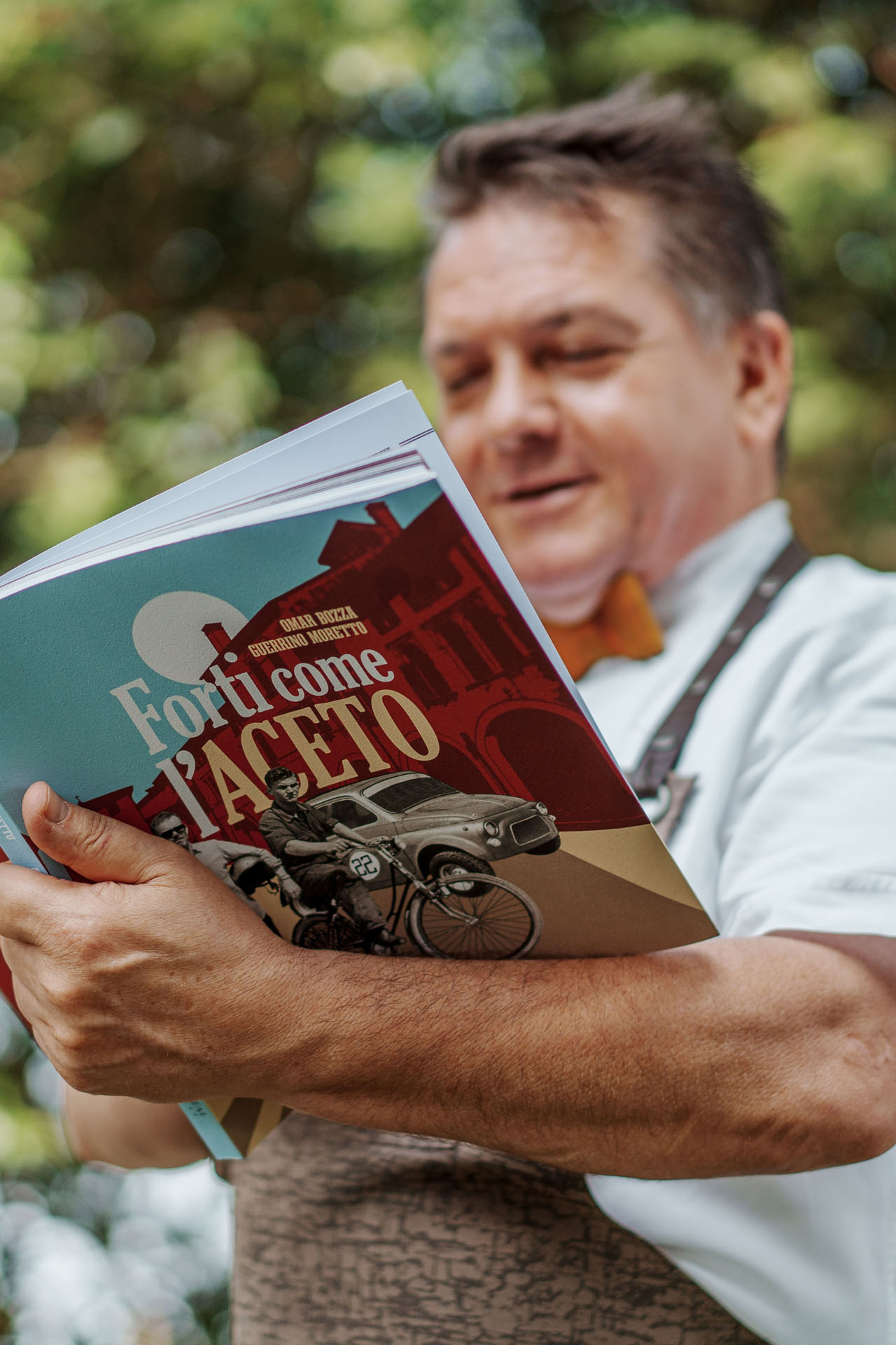 Alessandro Doretto sfoglia un libro presentato in occasione di un evento del Cenacolo delle Bricole, associazione culturale che si riunisce presso la trattoria.